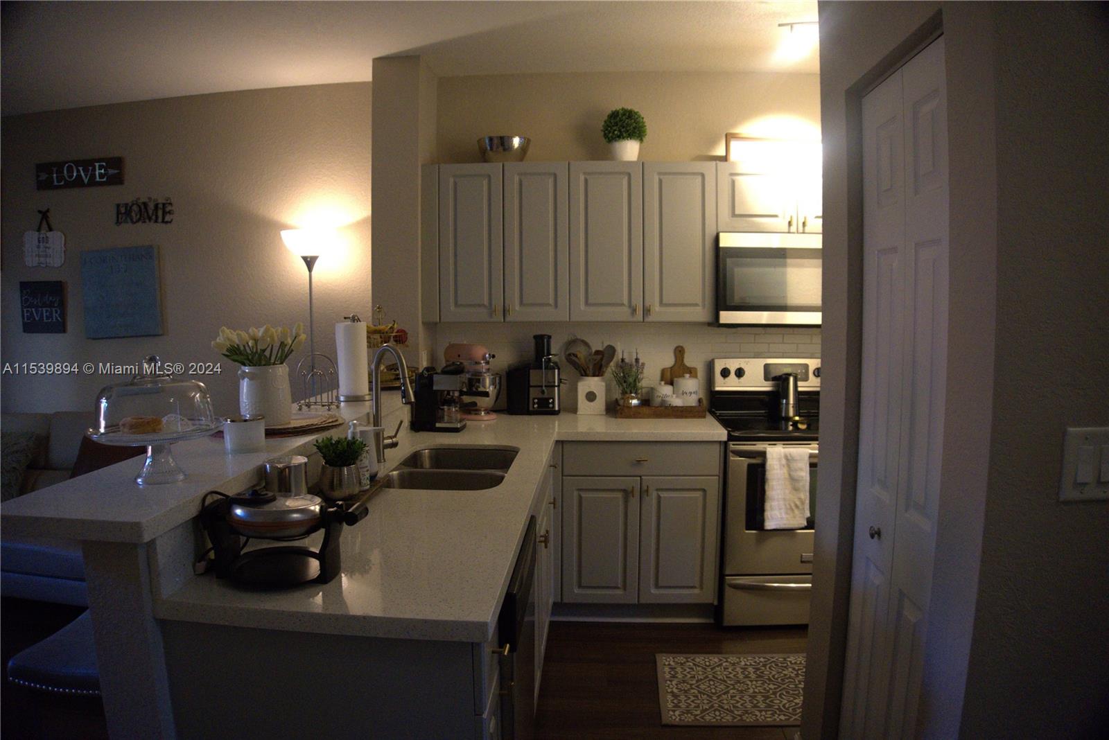9143 Southwest 227th Street, Unit 3 Cutler Bay, FL 33190 - Photo 11 of 35 a kitchen with a sink stove and cabinets