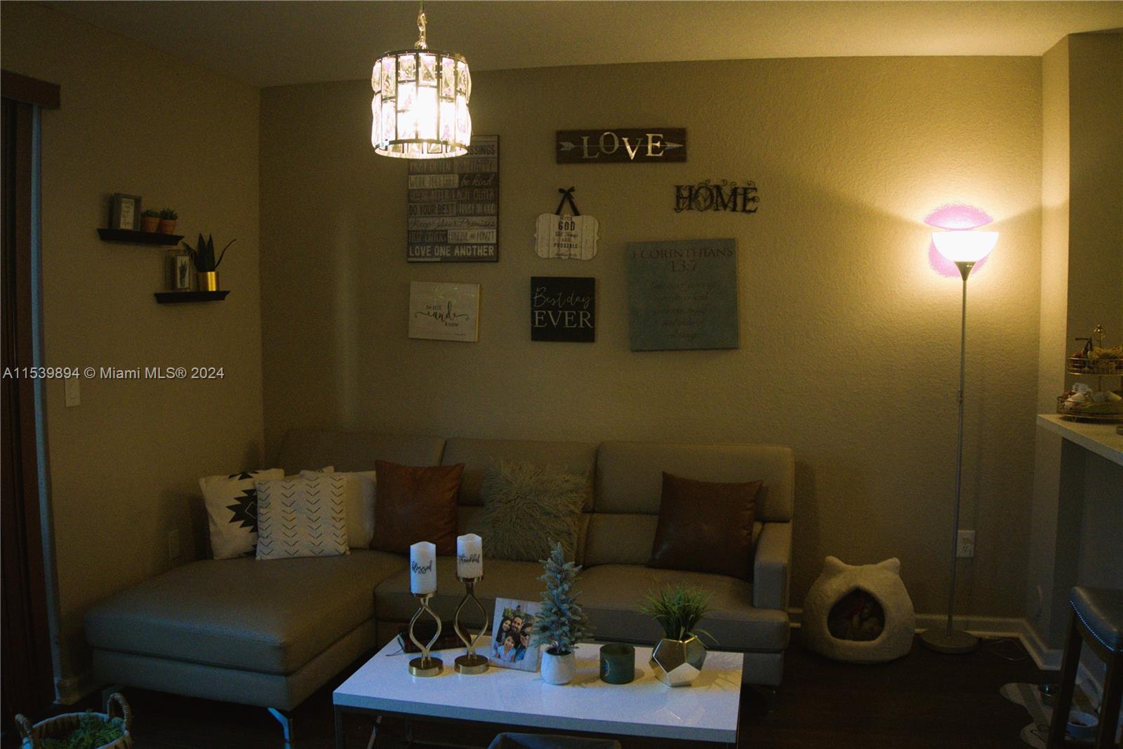 9143 Southwest 227th Street, Unit 3 Cutler Bay, FL 33190 - Photo 16 of 35 a living room with furniture and a chandelier