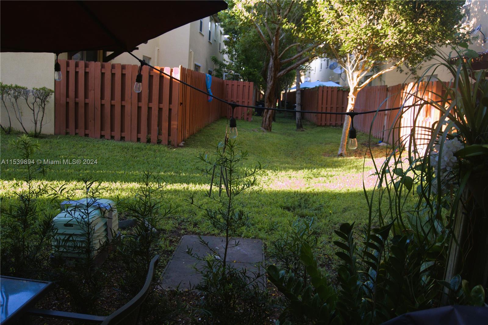 9143 Southwest 227th Street, Unit 3 Cutler Bay, FL 33190 - Photo 18 of 35 a backyard of a house with lots of green space