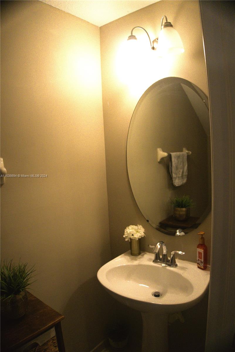 9143 Southwest 227th Street, Unit 3 Cutler Bay, FL 33190 - Photo 20 of 35 a bathroom with a sink and mirror