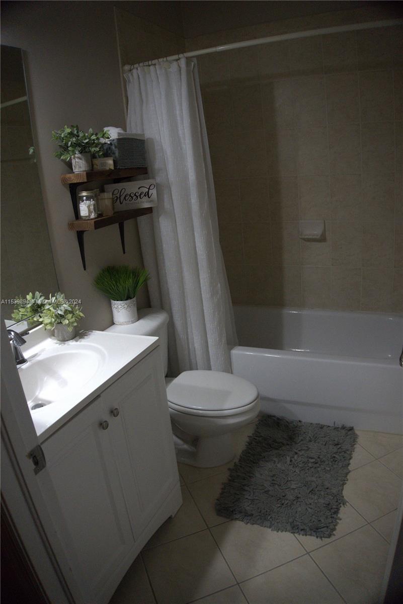 9143 Southwest 227th Street, Unit 3 Cutler Bay, FL 33190 - Photo 26 of 35 a bathroom with a toilet a sink and a shower