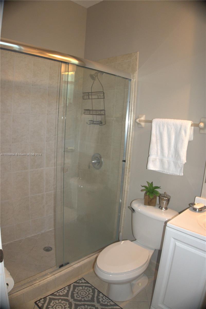 9143 Southwest 227th Street, Unit 3 Cutler Bay, FL 33190 - Photo 29 of 35 a white toilet sitting next to a bathroom sink
