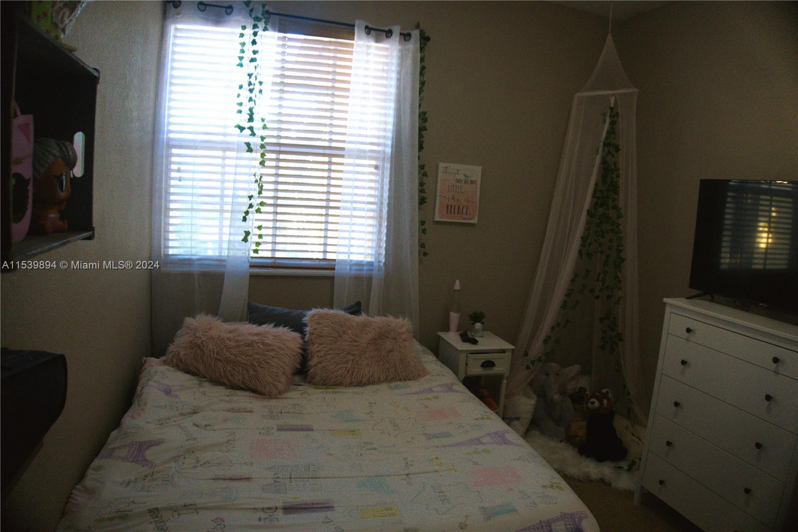 9143 Southwest 227th Street, Unit 3 Cutler Bay, FL 33190 - Photo 32 of 35 a bedroom with a bed and a flat tv screen on the dresser