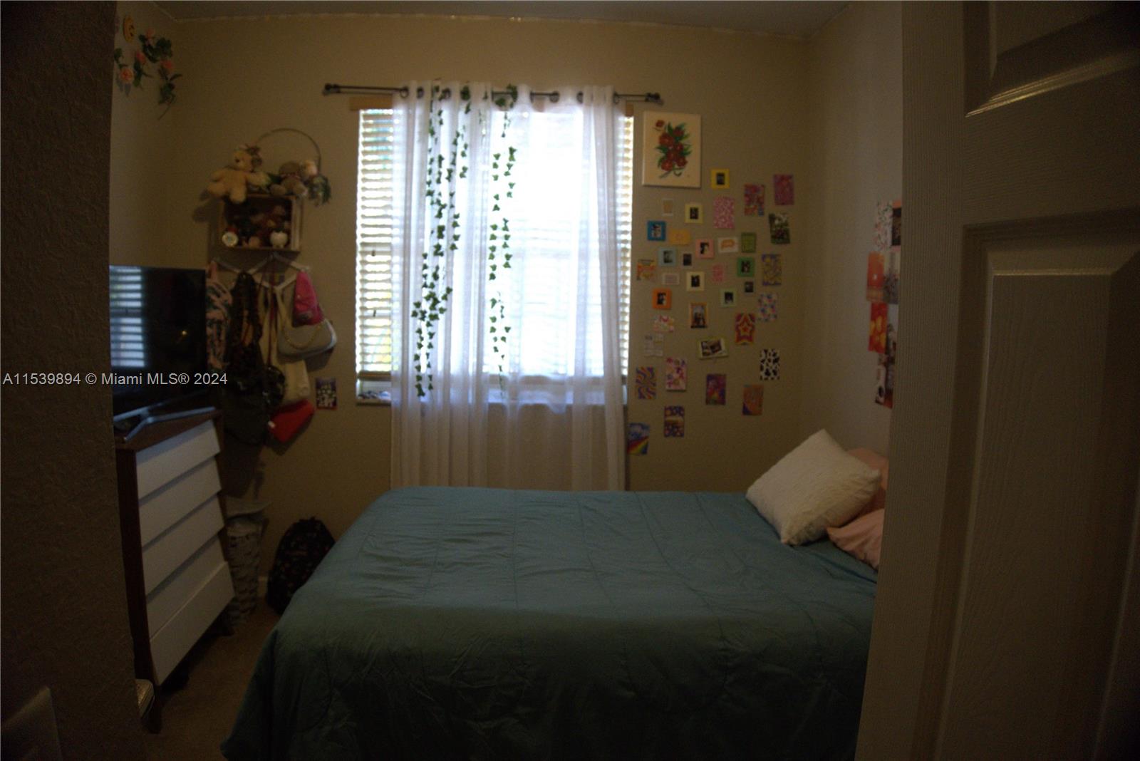 9143 Southwest 227th Street, Unit 3 Cutler Bay, FL 33190 - Photo 33 of 35 a bed sitting in a bedroom next to a window