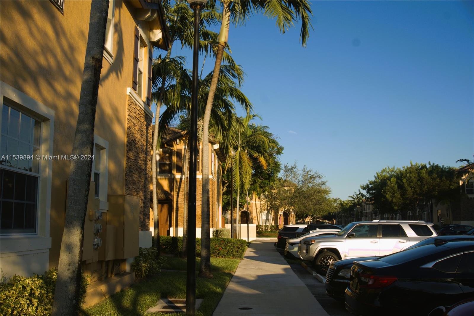 9143 Southwest 227th Street, Unit 3 Cutler Bay, FL 33190 - Photo 5 of 35 a view of a city street with a cars parked on the roadside