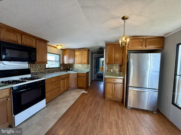 a kitchen with stainless steel appliances granite countertop a refrigerator a stove top oven a sink dishwasher and a refrigerator