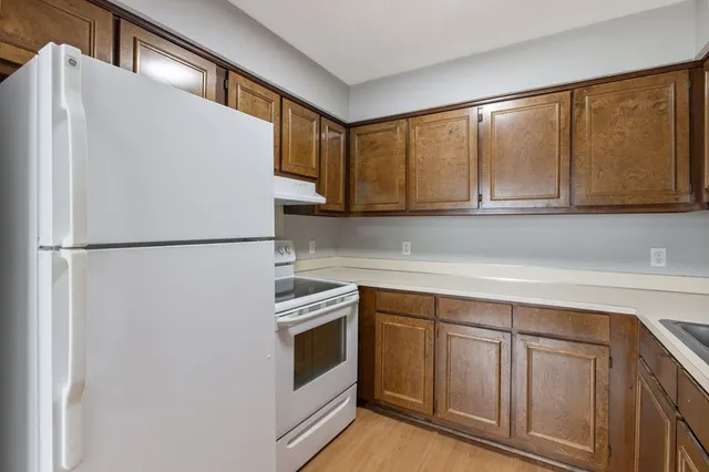 a kitchen with cabinets and white stainless steel appliances