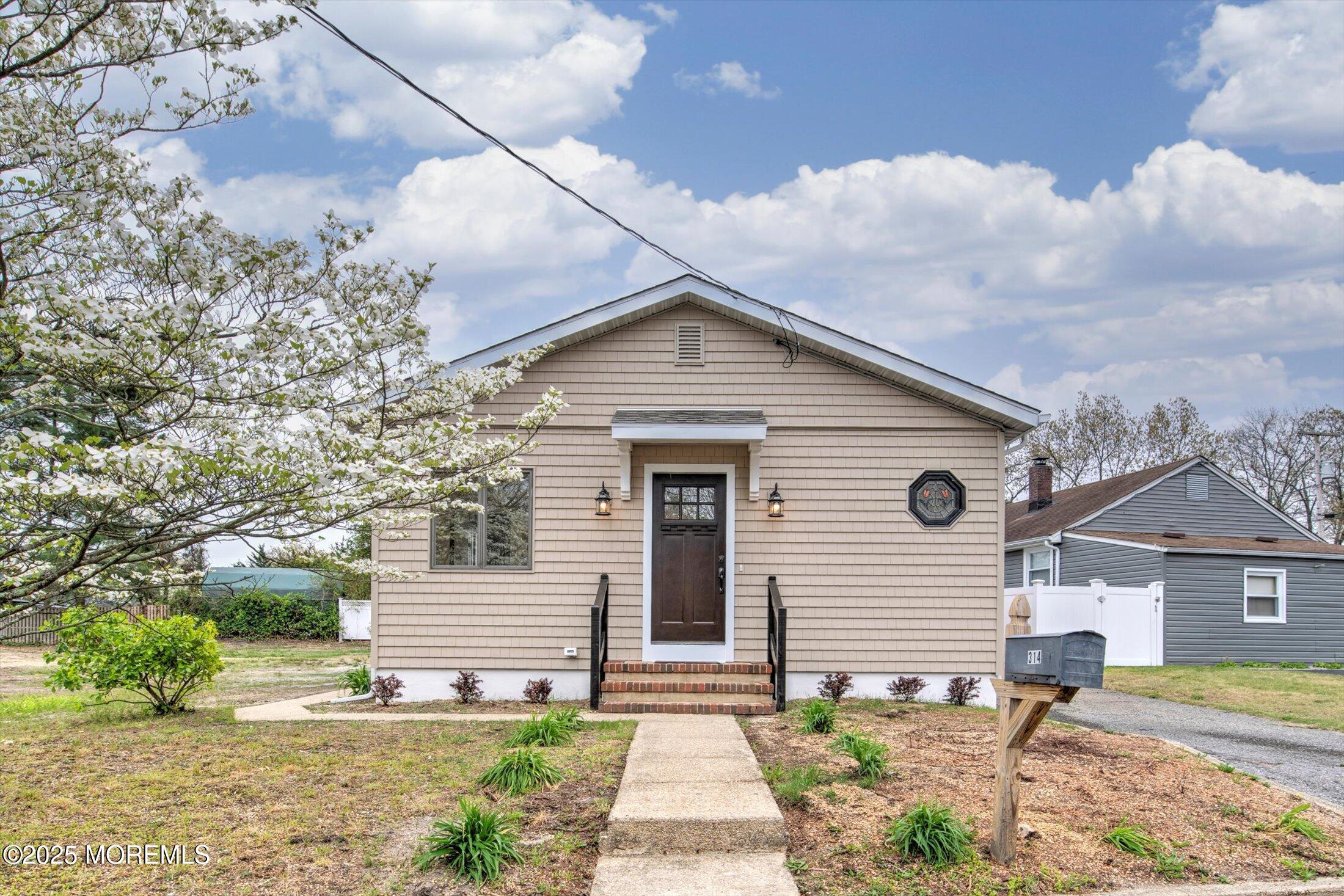 a front view of a house with a yard and potted plants