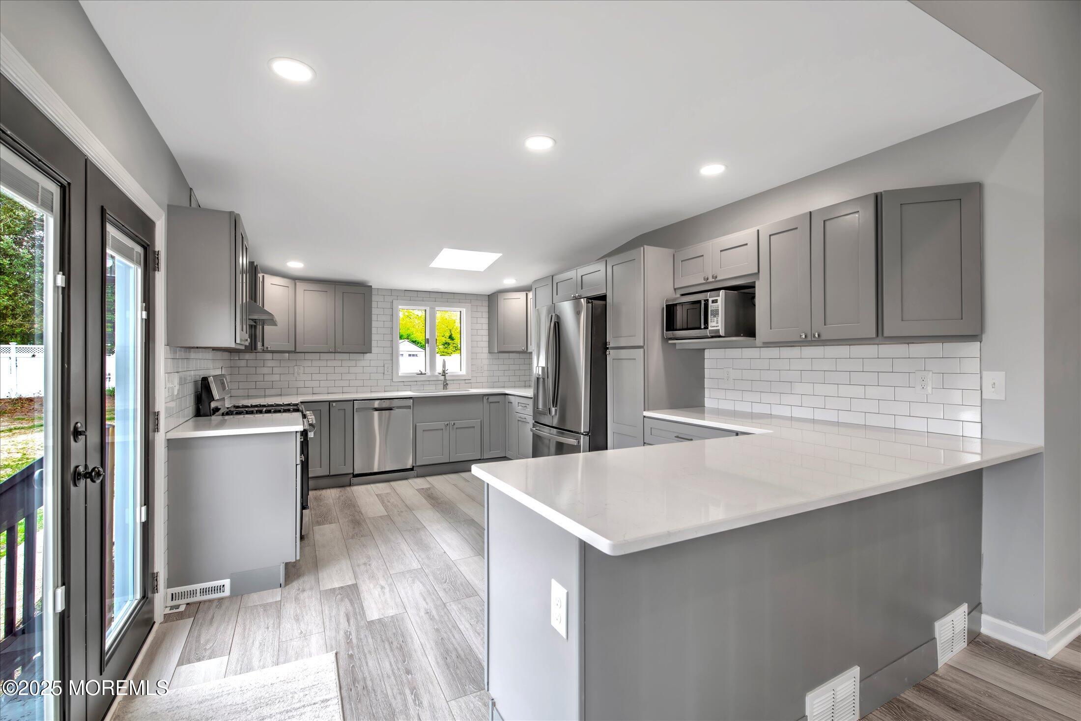 314 Motor Road Pine Beach, NJ 08741 - Photo 11 of 38 a large kitchen with stainless steel appliances kitchen island a large counter top and a refrigerator