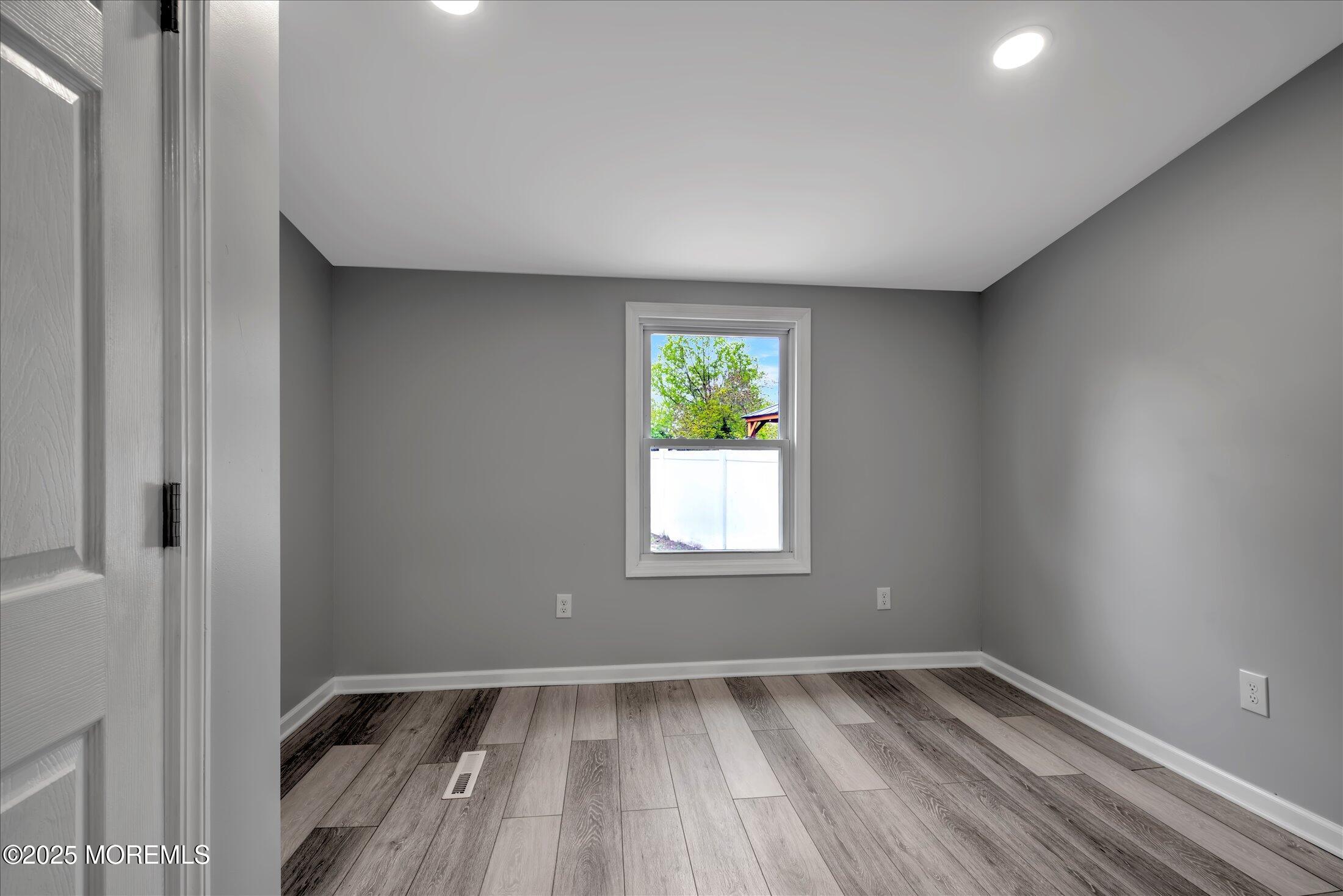 314 Motor Road Pine Beach, NJ 08741 - Photo 27 of 38 an empty room with wooden floor and windows