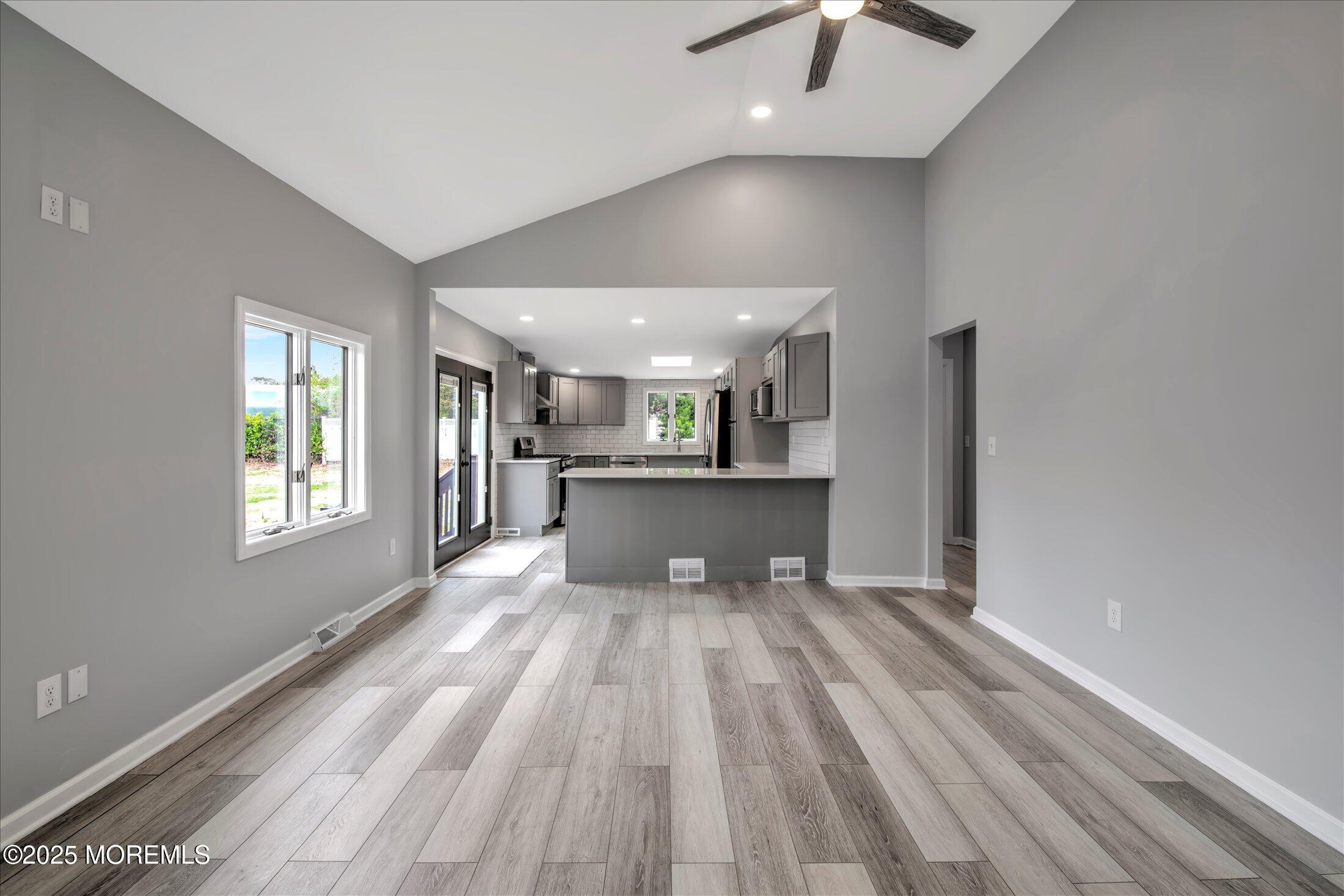 314 Motor Road Pine Beach, NJ 08741 - Photo 5 of 38 a view of a big room with wooden floor a chandelier fan and windows