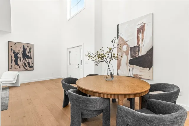 a kitchen with a dining table chairs and refrigerator
