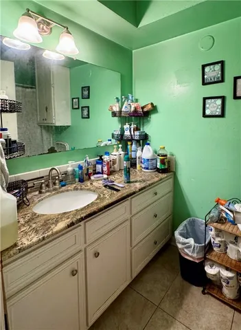 a bathroom with a granite countertop sink and a mirror