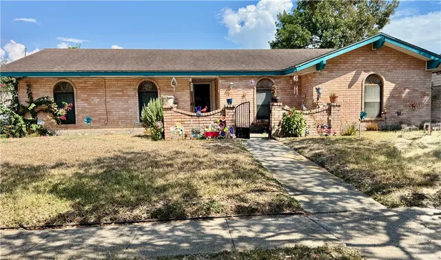 a front view of a house with large trees and covered with yard