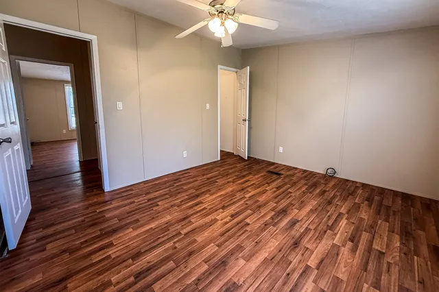 a view of a livingroom with wooden floor and a ceiling fan