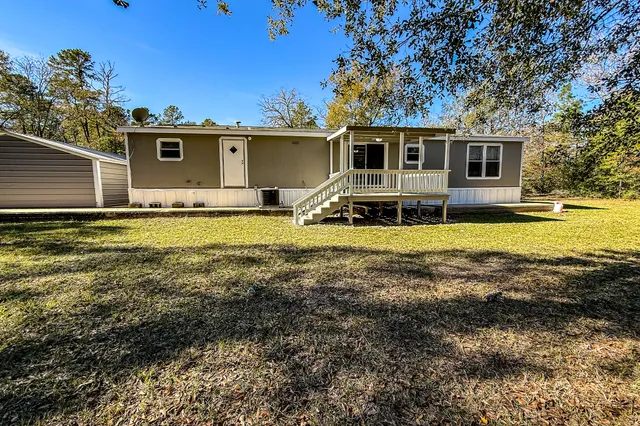 a view of a house with a big yard and swimming pool