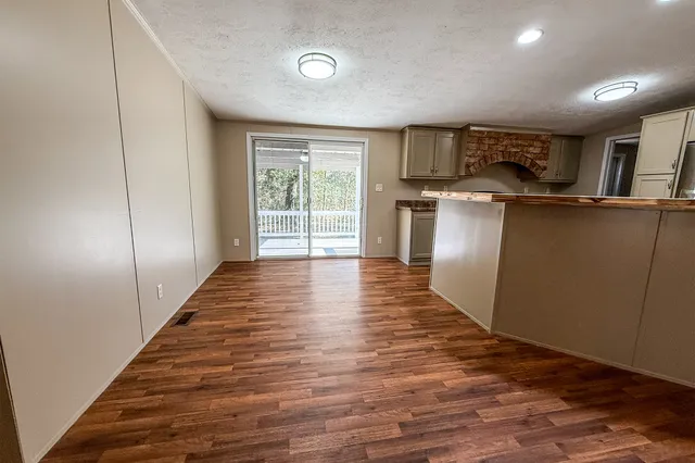 a view of a kitchen with wooden floor and electronic appliances