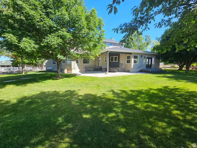 812 East Bates Cyn Road Tooele, UT 84074 - Photo 143 of 144 Expansive green lawn with mature trees and a concrete patio