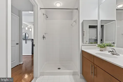 a bathroom with a shower sink and mirror
