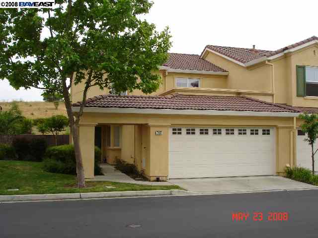a view of a white house with a large tree