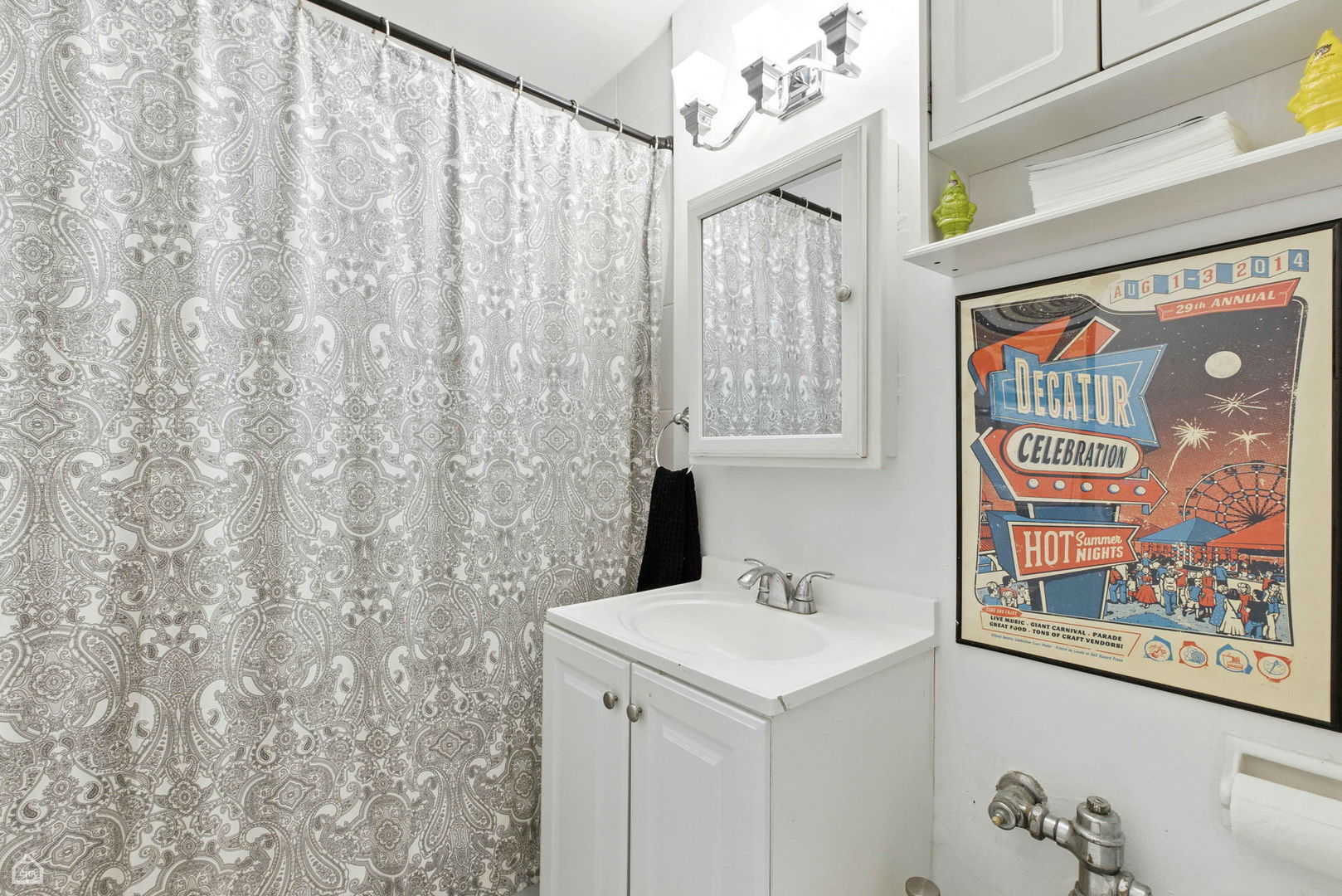 700 West Bittersweet Place, Unit 904 Chicago, IL 60613 - Photo 9 of 11 a bathroom with a sink and a shower curtain