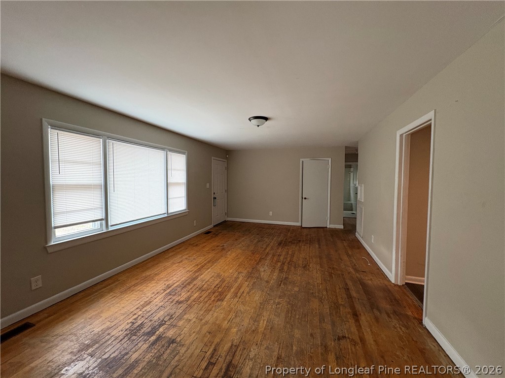440 North Grogg Street Spring Lake, NC 28390 - Photo 5 of 23 an empty room with wooden floor and windows