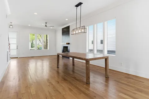 a large kitchen with kitchen island granite countertop a stove a sink and a wooden floor