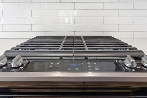 a kitchen with stainless steel appliances granite countertop a refrigerator a sink and a wooden floor