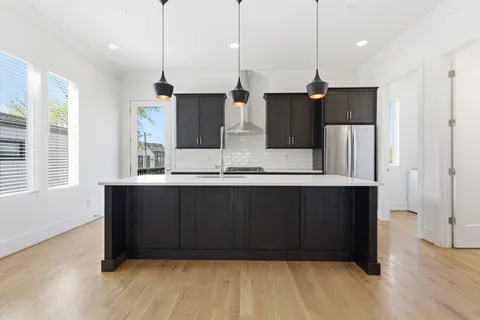 a kitchen with stainless steel appliances granite countertop a sink stove and refrigerator