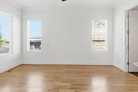 a view of an empty room with wooden floor