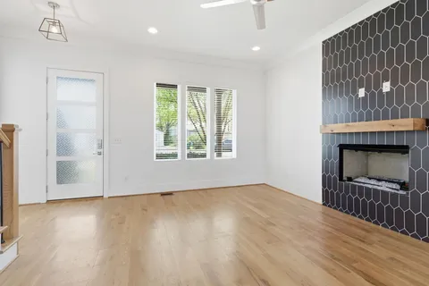 an empty room with wooden floor and entrance