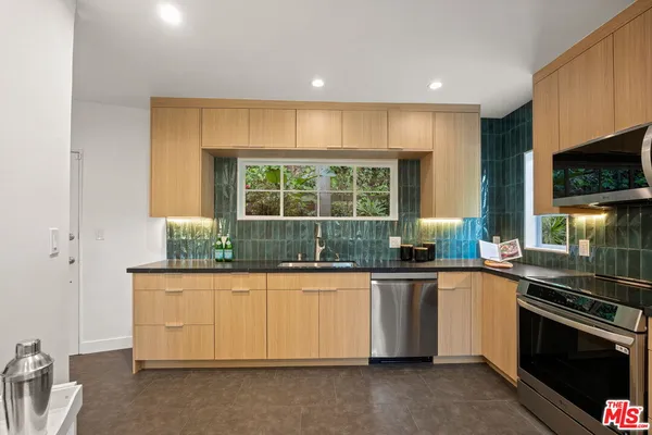 a kitchen with stainless steel appliances granite countertop a stove and a sink