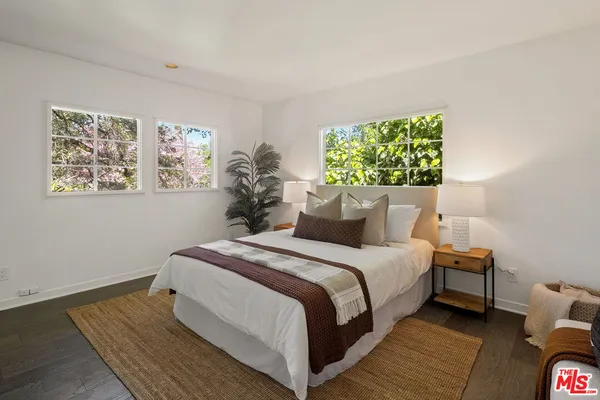 a bedroom with bed and a painting on the wall
