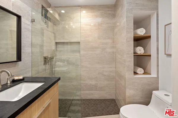 a bathroom with a granite countertop sink toilet and shower