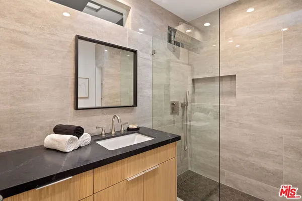 a bathroom with a granite countertop sink mirror and vanity