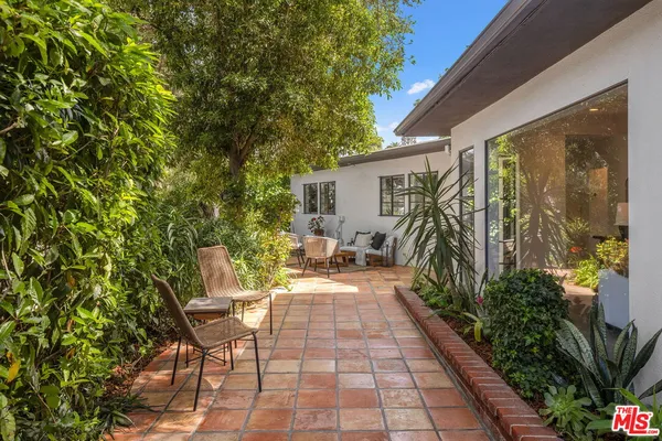 a view of a chairs and table in backyard of the house
