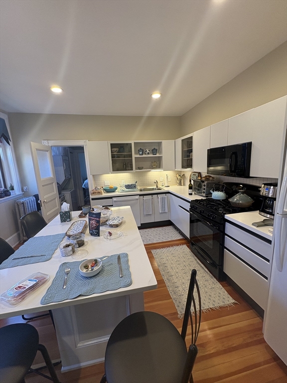 24 Beaufort Road, Unit 3 Boston, MA 02130 - Photo 31 of 32 a kitchen with a table chairs stove and kitchen island