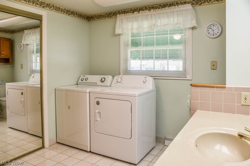 4877 4th Street Northwest Canton, OH 44708 - Photo 17 of 24 The third bedroom was converted into a 1st floor laundry room and 2nd full bath - washer and dryer convey (2019), stand up shower, tile floor and new toilet!