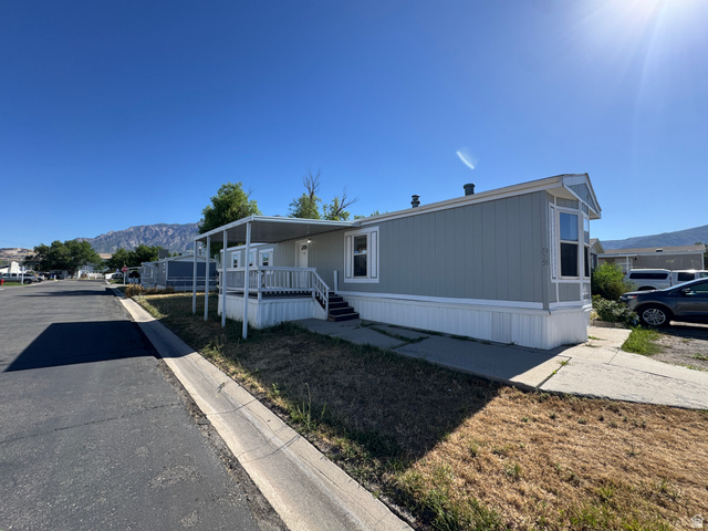 2491 Highway 89, Unit 315 Pleasant View, UT 84404 - Photo 5 of 34 Light blue siding exterior with white trim and a covered front porch featuring white railings
