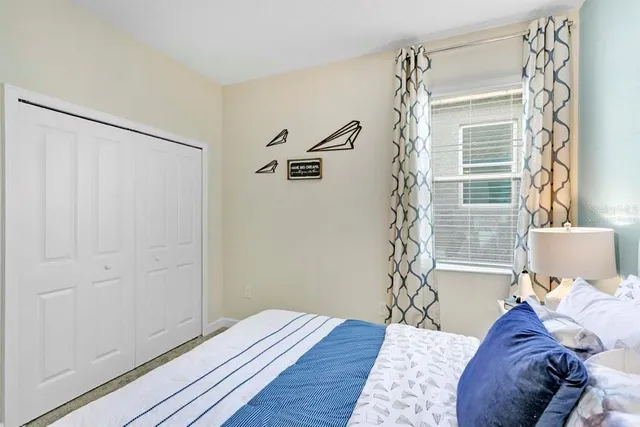 a view of a bedroom with a bed and wooden floor