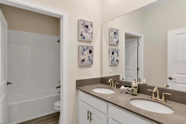 a bathroom with a granite countertop tub sink and mirror