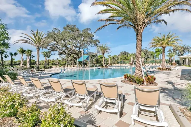 a swimming pool with outdoor seating and plants