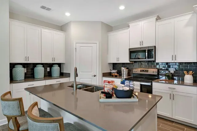 a kitchen with a sink a microwave and cabinets