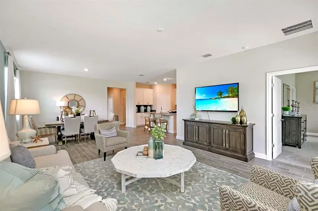 a living room with furniture a flat screen tv and a table