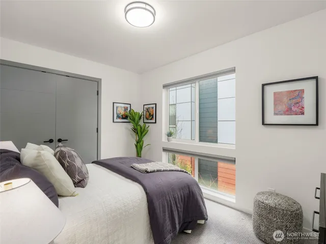 a bedroom with a bed painting on wall and a window