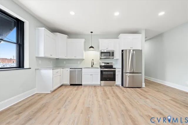 a kitchen with granite countertop a refrigerator and a sink