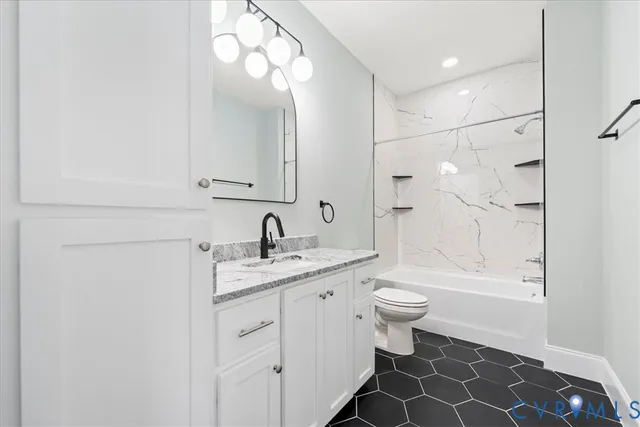 a bathroom with a granite countertop sink a toilet and shower