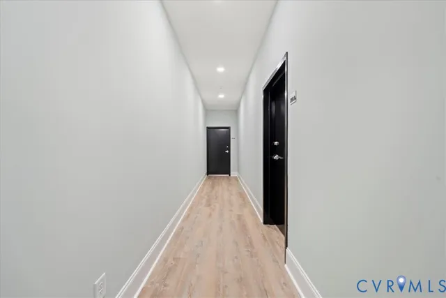 a view of hallway with wooden floor