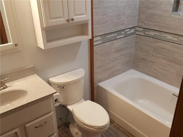 a white toilet sitting next to a bath tub