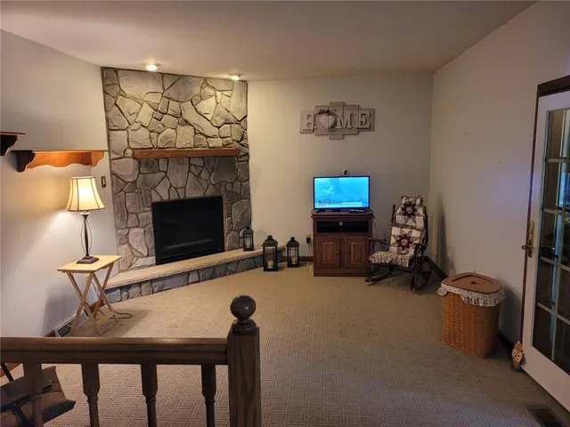 a living room with furniture a flat screen tv and a fireplace